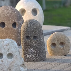 funny cute art rock set, grey and pink and white limestone, minimalist eye holes excavated with high speed drill