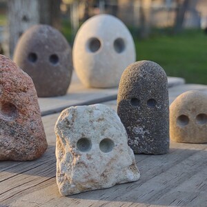 funny cute art rock set, grey and pink and white limestone, minimalist eye holes excavated with high speed drill