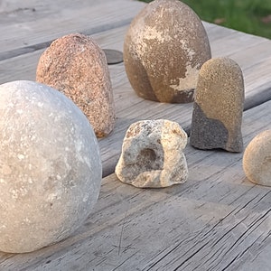 funny cute art rock set, grey and pink and white limestone, minimalist eye holes excavated with high speed drill