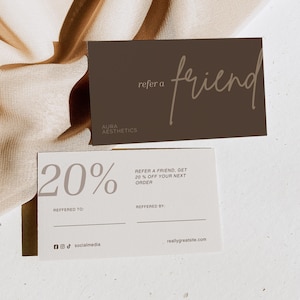 May include: Two rectangular referral cards. The top card is dark brown with the text "refer a friend" and "AURA AESTHETICS". The bottom card is white with the text "20%", "REFER A FRIEND, GET 20% OFF YOUR NEXT ORDER", "REFFERED TO:", "REFFERED BY:", social media icons, and a website URL.