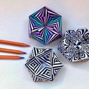 May include: Three geometric paper sculptures with hexagonal shapes. One features a vibrant purple, blue, and black radial pattern. Another displays a black and white floral-like design. The third has a black and white triangular pattern.