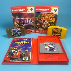 Może przedstawiać: Trzy gry wideo na konsolę Nintendo 64, w tym The Legend of Zelda: Majora's Mask, Donkey Kong 64 oraz Mario Kart 64. Kolekcja zawiera dwa pudełka z grami, dwie kasety w kolorze złotym i żółtym oraz czerwone plastikowe etui z instrukcją i kasetą.