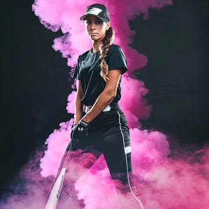 May include: A woman wearing a black baseball cap, black shirt, and black pants with white stripes stands in front of a pink smoke background. She is holding a baseball bat.