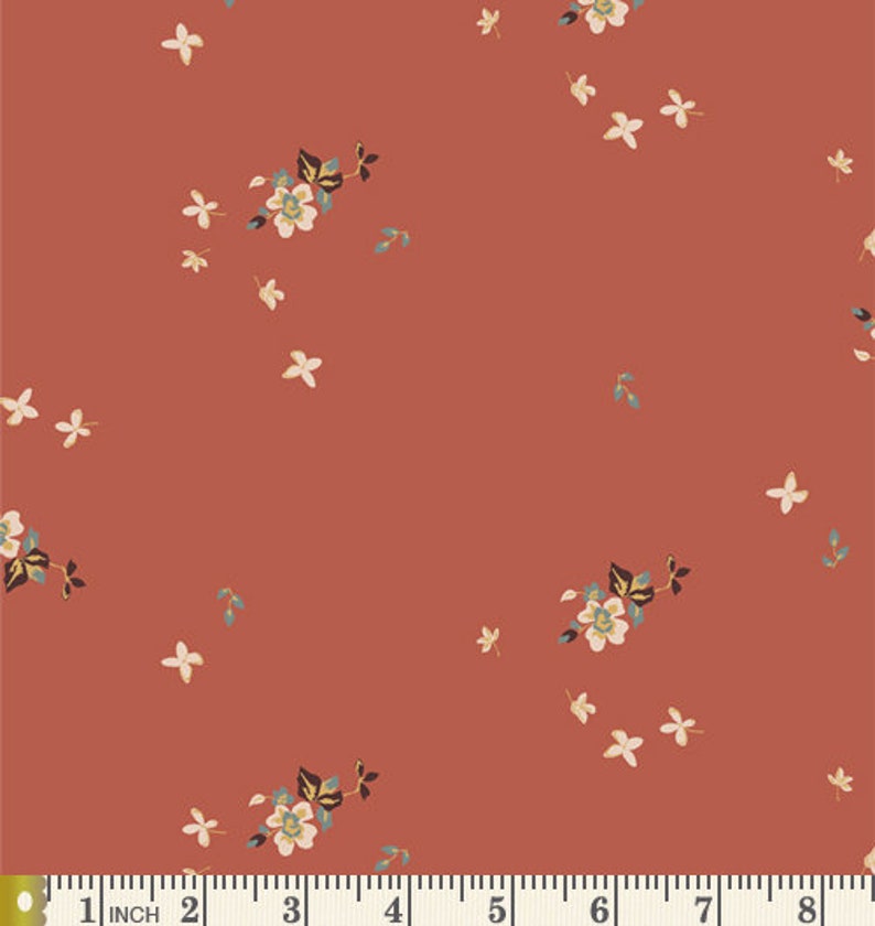 May include: A red fabric with a white floral pattern. The flowers are small and delicate, with a few larger flowers scattered throughout. The fabric has a subtle texture.