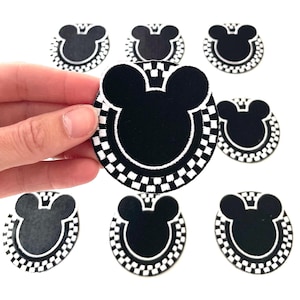 May include: Eight black and white iron-on patches featuring a Mickey Mouse silhouette with a checkered border.