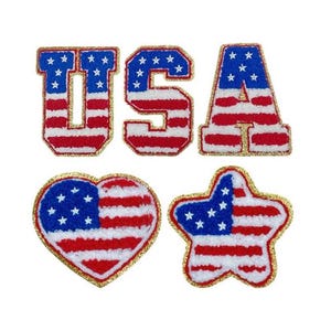 May include: Four iron-on patches with an American flag design. The patches are in the shape of the letters U, S, A, a heart, and a star. The patches are red, white, and blue with gold trim.