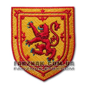 May include: Embroidered patch featuring the Scottish national coat of arms, a red lion rampant on a yellow field, surrounded by a gold border.
