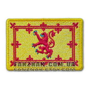 May include: A yellow embroidered patch featuring a red lion rampant, the national symbol of Scotland. The patch is bordered in yellow with a decorative pattern. The text "FANZNAK.COM.UA" and "FANZNAK.ETSY.COM" is printed below the patch.