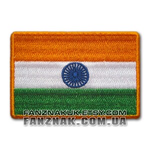May include: An embroidered patch of the Indian flag. The flag is a tri-colour of orange, white, and green with a blue wheel in the centre of the white stripe. The text "FANZNAKUK.ETSY.COM FANZNAK.COM.UA" is printed below the flag.