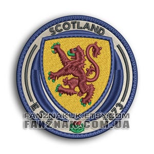 May include: A circular embroidered patch featuring a yellow shield with a maroon rampant lion. The word SCOTLAND is arched at the top. The border is blue with white accents and the text FANZNAKUK.ETSY.COM and FANZNAK.COM.UA at the bottom.