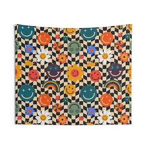 May include: A tapestry with a repeating pattern of smiley faces, flowers, rainbows, and other retro-style graphics. The background is a black and tan checkerboard pattern. The colors include orange, yellow, blue, and green.
