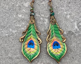 Shimmering green peacock eye leather feather earrings with faceted glass beads. Boho chic dangle earrings with wirework details.