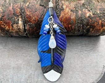 Blue jay feather leather pendant with sterling silver wirework and gemstones. Hand tooled and painted leather w/ kyanite, lapis & moonstone