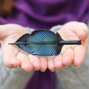 Raven feather ponytail holder with wood stick, gift for corvid lover. Small tooled leather shawl pin in black w/ iridescent blues and greens