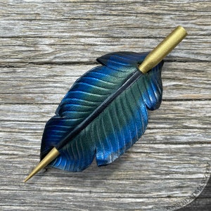Raven feather ponytail holder with wood stick. Small tooled leather shawl pin in black w/ iridescent blues and greens. Gift for corvid lover 4.75" gold stick