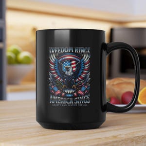 May include: Black ceramic mug featuring a patriotic design with an eagle, American flag, and the text "FREEDOM RINGS AMERICA SINGS". The mug has a large handle and is suitable for hot or cold beverages.