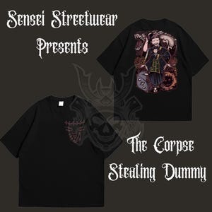 May include: Black t-shirts with graphic designs. One shirt features a detailed illustration of a character with a dragon, the text "The Corpse Stealing Dummy". The other shirt has a small red design.