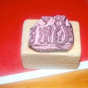 May include: A pink rubber stamp with an abstract design and the text "Element41" on a wooden block.
