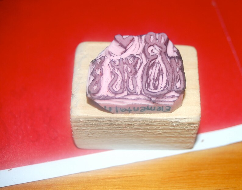 May include: A pink rubber stamp with an abstract design and the text "Element41" on a wooden block.
