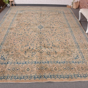 Puede incluir: Una alfombra grande de color beige con un patrón floral azul. La alfombra tiene un borde detallado con un diseño repetitivo.