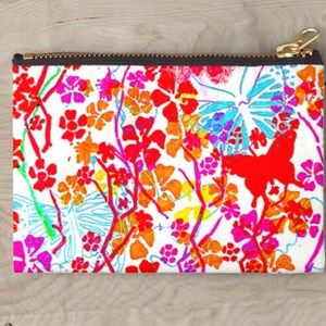 May include: A white zippered pouch with a colorful floral and butterfly print. The print features red, orange, yellow, pink, blue, and green colors.