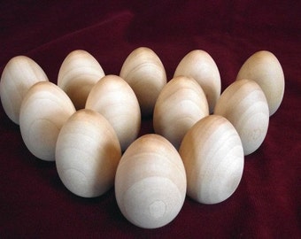 May include: A group of 11 smooth, white, wooden eggs arranged in a circle on a red velvet surface.