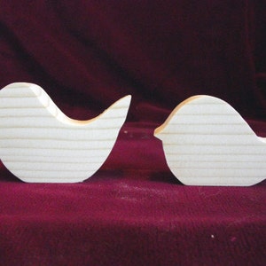 Puede incluir: Dos formas de p&aacute;jaros de madera sin terminar. Los p&aacute;jaros son siluetas simples sin detalles. Los p&aacute;jaros est&aacute;n mirando en diferentes direcciones.