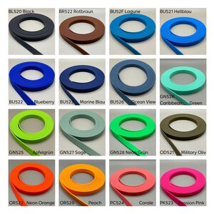 May include: A collection of sixteen coiled strips of flat material in various colors, including black, brown, blue, green, orange, and pink. Each coil is labeled with a specific code and color name, such as BL520 Black, BU522 Blueberry, and PK523 Passion Pink.