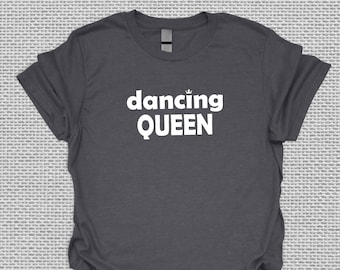 May include: A dark gray t-shirt with the text "dancing QUEEN" in white lettering. A small crown symbol is above the word "dancing".