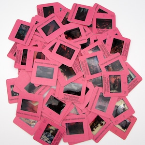 May include: A collection of vintage pink slide film mounts, each containing a small image. The slides are labeled "The World History Slide Collection" and "This Side Toward Screen". The images appear to be historical scenes.