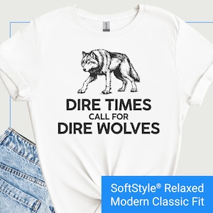 May include: White t-shirt with a black and white illustration of a wolf and the text "Dire Times Call For Dire Wolves".