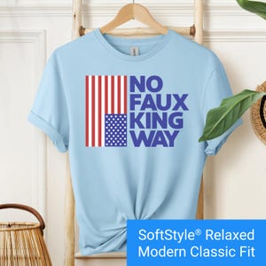 Light blue t-shirt with an inverted "in distress" American flag hanging vertically next to large text reading "No Faux King Way."