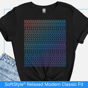 May include: Black t-shirt with a geometric design in a gradient of colors from red to blue. The design is composed of repeating shapes and lines. The text "SoftStyle Relaxed Modern Classic Fit" is at the bottom.