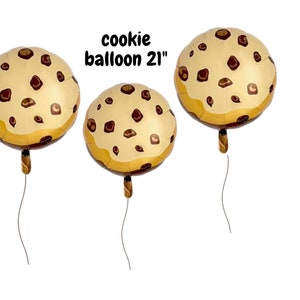 Peut inclure: Trois ballons ronds en forme de cookie, chacun de 53 cm de diamètre, avec une base marron clair et des détails de pépites de chocolat marron foncé. Les ballons ont un bord brun doré et un ruban marron. Le texte sur l'image indique "cookie balloon 21".