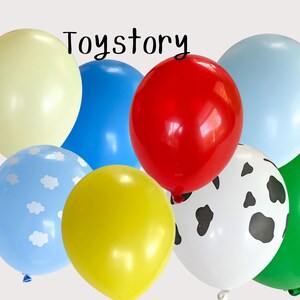 Puede incluir: Una colecci&oacute;n de globos coloridos en varios tonos, incluyendo rojo, azul, amarillo, verde y un globo blanco con manchas negras. Un globo tiene un fondo azul claro con formas de nubes blancas. La palabra "Toystory" est&aacute; escrita en la parte superior.