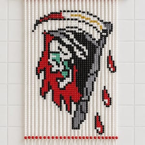 May include: A wall hanging made of white, red, and black beads strung on white cord from a wooden dowel. The bead pattern depicts a stylized grim reaper figure in black, red, white, and green, with three red and black teardrop shapes below.