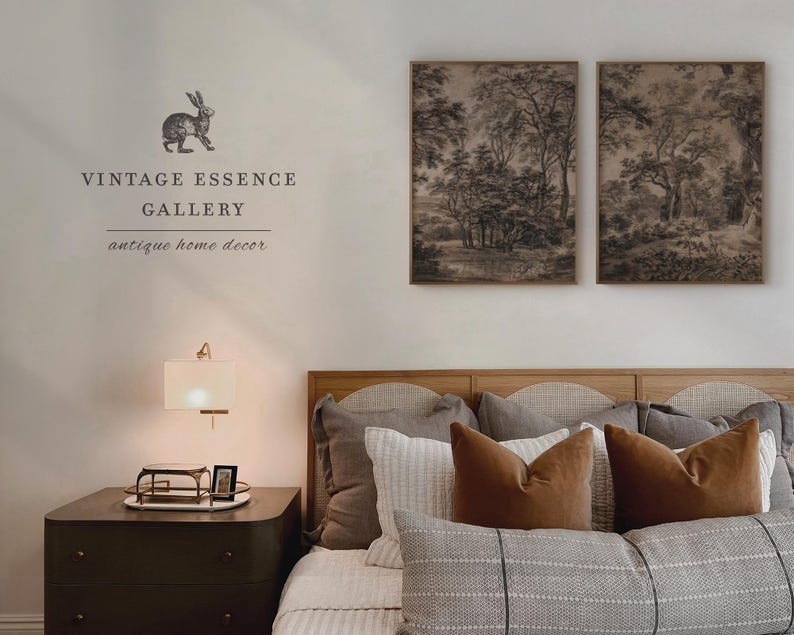 May include: A bedroom interior with a wooden headboard and a bed dressed in a gray and white striped duvet cover. Two framed black and white landscape prints hang above the headboard. A bedside table with a lamp and a small framed picture sits next to the bed. The text "Vintage Essence Gallery, antique home decor" is printed on the wall.