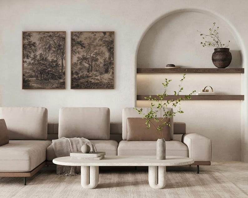 May include: A light beige sectional sofa with a brown throw blanket and a white marble coffee table with a unique curved base. The sofa is in a living room with a white wall and a niche with shelves and a vase with dried branches.