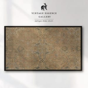 May include: A framed, rectangular artwork featuring a detailed, aged rug design in shades of brown, beige, and muted blue. The rug pattern is symmetrical with floral and geometric elements. The artwork is framed in a black border. The text "VINTAGE ESSENCE GALLERY antique home decor" is above the artwork.