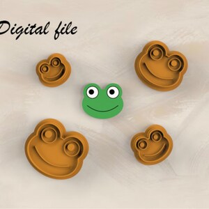 May include: Four brown frog-shaped cookie cutters of varying sizes and one green frog face cutout. The text "Digital file" is visible in the upper left corner. The cutters feature raised outlines for eyes and a curved mouth on each frog face.