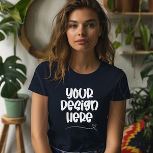 Puede incluir: Una mujer lleva una camiseta azul oscuro con el texto "your design here" en blanco. La camiseta tiene cuello redondo y mangas cortas.
