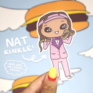 May include: A sticker featuring a cartoon illustration of a person with brown hair wearing a pink suit and a pink hat. The person is holding a snake in their right hand. The sticker has the text "NAT KINKLE!" and "AND HER PET SNAKE, STEVE!" on it.