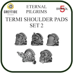 Peut inclure: Ensemble de six épaulettes en plastique gris pour figurines miniatures. Les épaulettes présentent divers motifs, dont une épée, un crâne et une figure ailée. Le texte "Eternal Pilgrims" et "Termi Shoulder Pads Set 2" est imprimé sur l'image.