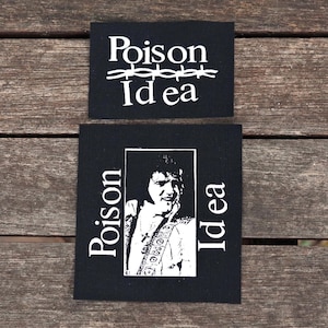 May include: Two black fabric patches. The top patch has the words "Poison Idea" in white, with barbed wire above the word "Idea". The bottom patch features a black and white image of a person with the words "Poison Idea" on either side.