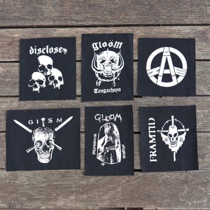 Peut inclure: Six patchs brodés noir et blanc avec des noms de groupes et des logos. Les patchs comprennent : Disclose, Gloom Tengachaya, un symbole anarchique, GISM, Gloom Records of Reprobation et Framtid.