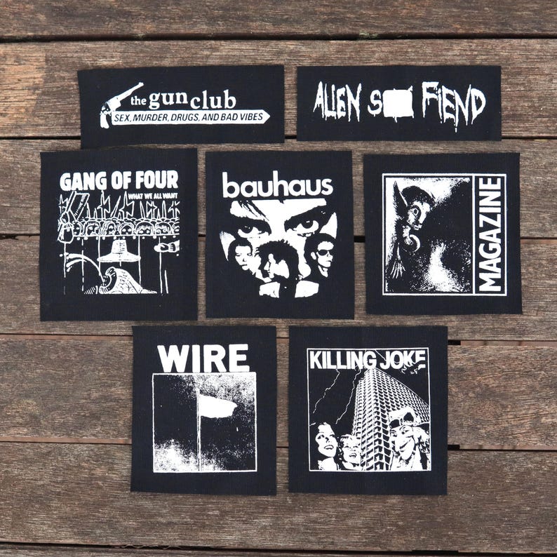 May include: Collection of black and white patches featuring band logos and text. Patches include "the gun club", "Alien Sex Fiend", "Gang of Four", "Bauhaus", "Magazine", "Wire", and "Killing Joke". The patches are square and rectangular.