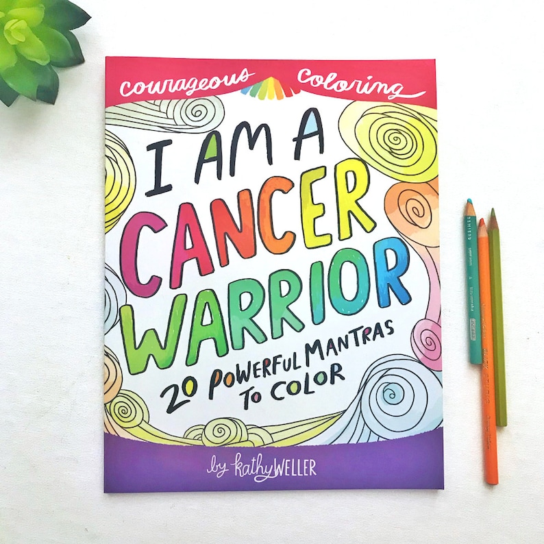 May include: A purple and pink colouring book with the title "I Am A Cancer Warrior" and the text "20 Powerful Mantras To Colour" by kathy WELLER.