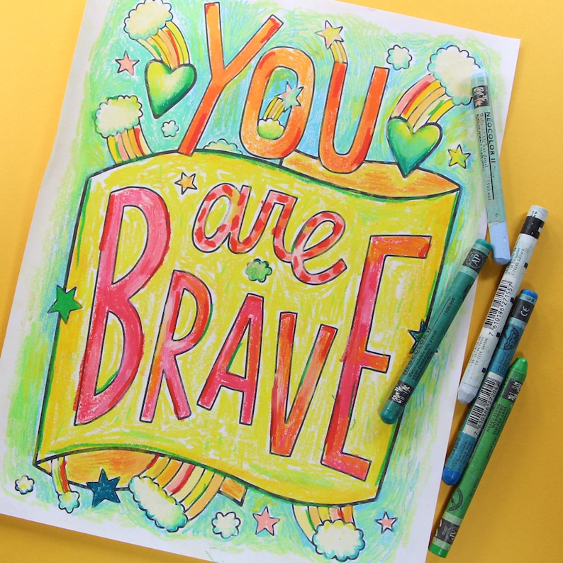 May include: A colourful printable colouring page with the text "You are Brave" in a rainbow banner design. The page features stars, hearts and clouds.