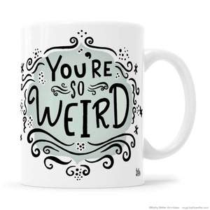 May include: White ceramic mug with a black and white design. The design features a light blue background with the text "You're so weird" in a whimsical font.