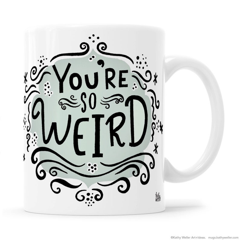 May include: White ceramic mug with a black and white design. The design features a light blue background with the text "You're so weird" in a whimsical font.